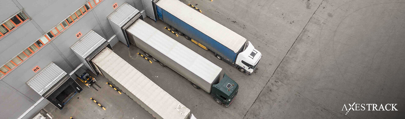 Aerial view of trucks queued at warehouse loading docks, representing dock scheduling and slot-based loading operations